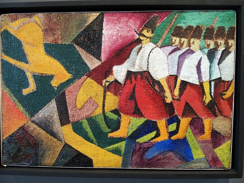 Colorful paining with a group of men in red trousers and black hats on the right.