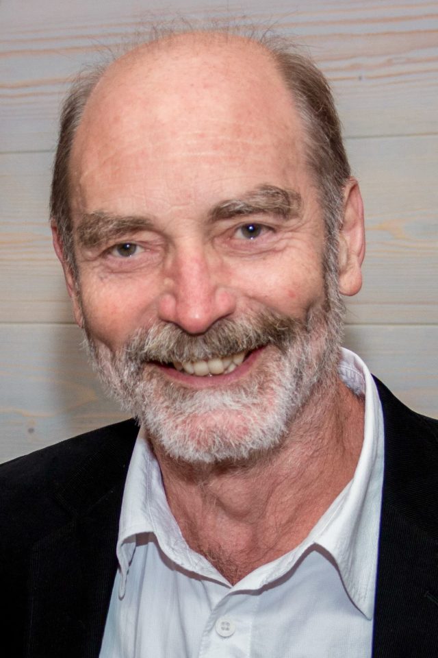 Fotoporträt eines lächelnden Mannes mit Bart